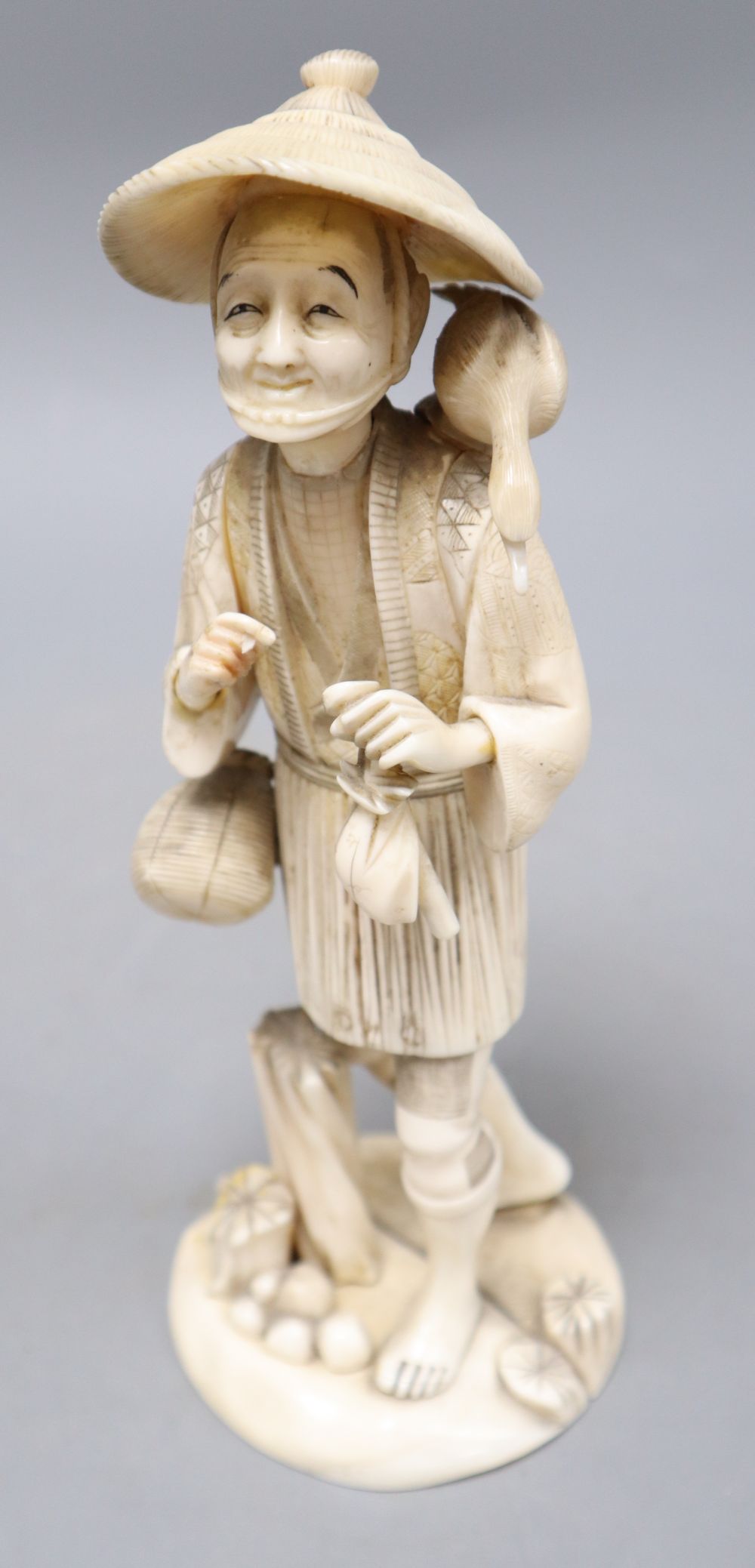 A Japanese sectional walrus ivory figure of a cormorant fisherman, character marks to base, height 23cm
